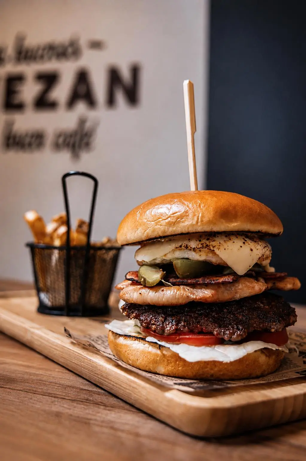 Hamburguesa premium con doble carne, bacon, huevo y queso fundido junto a patatas fritas